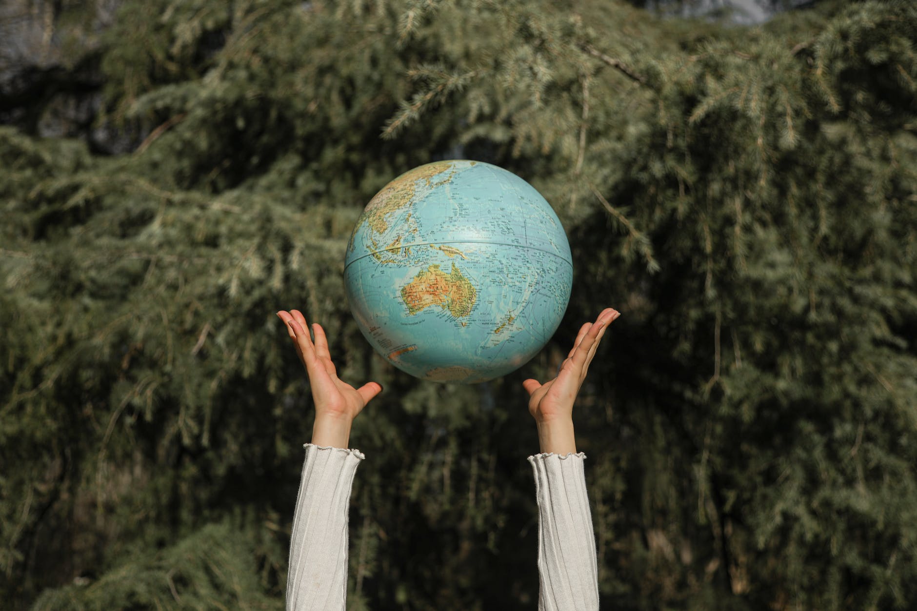person tossing a globe