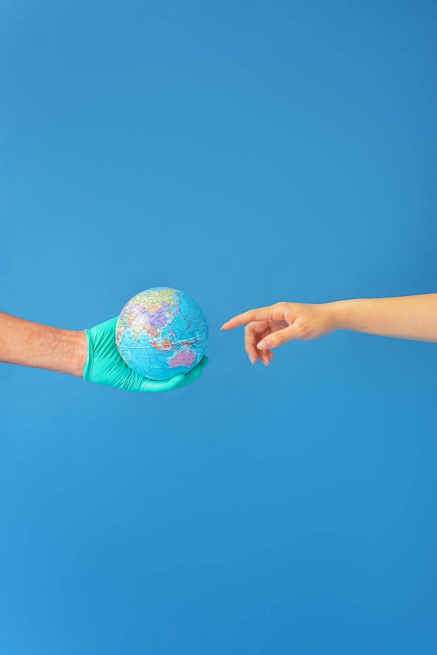 person wearing latex gloves holding a globe