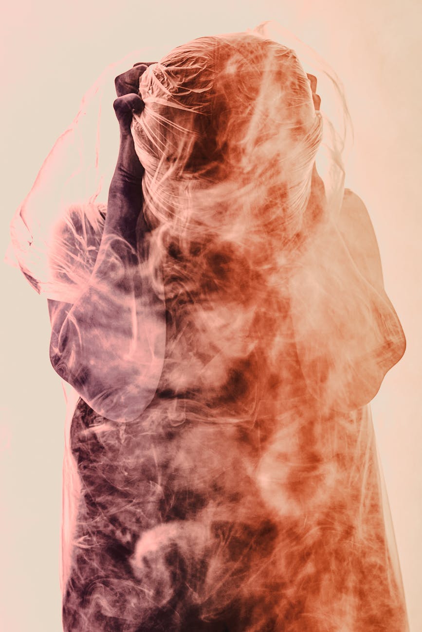 a picture of a person displaying despair surrounded with smoke
