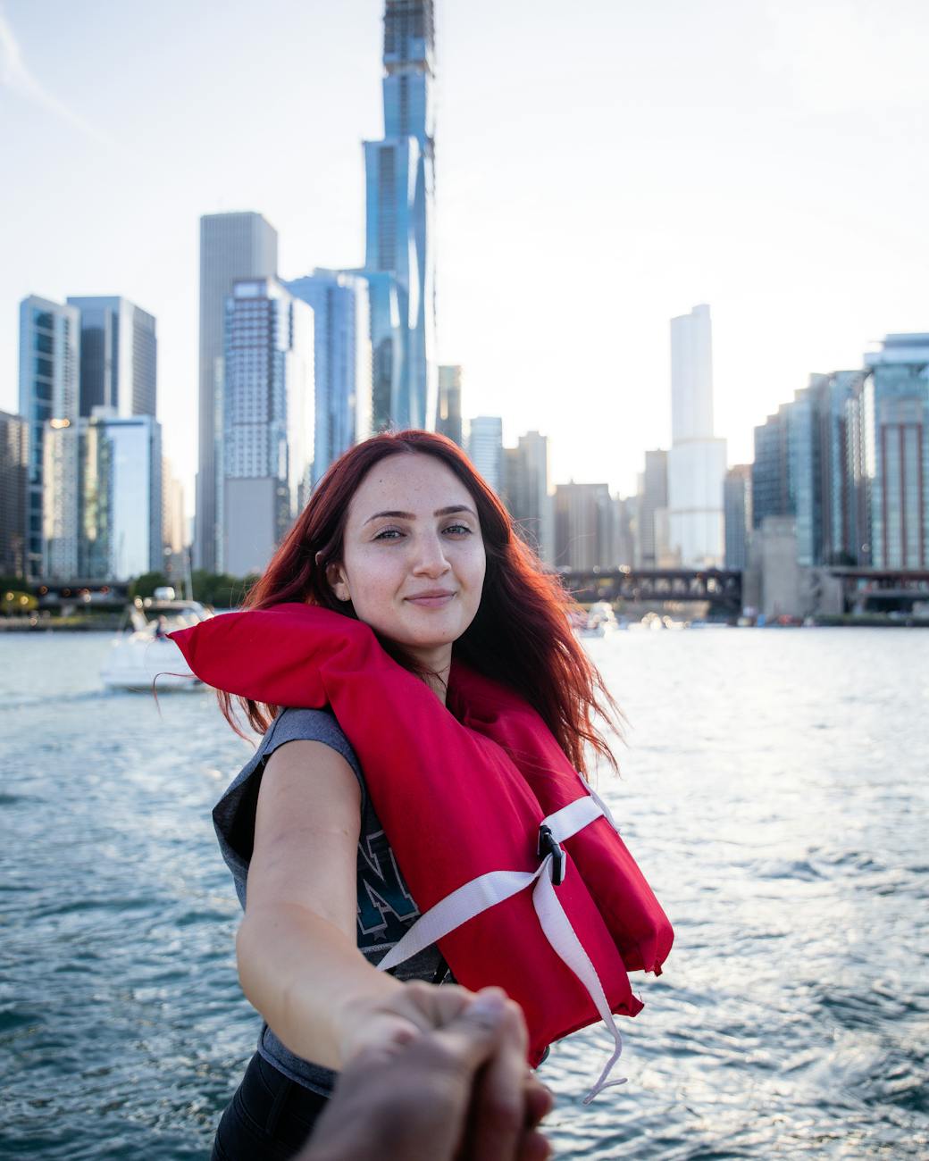 woman taking selfie in front of high rise building under white sky